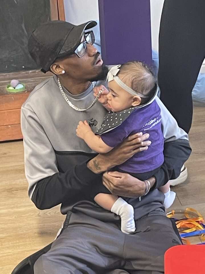 A man holds his baby daughter at a messy play class at Little Learners Playspace Ashington