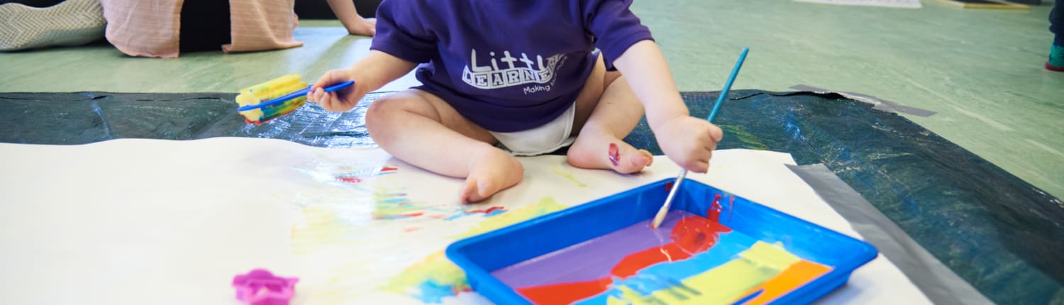 Little Learners Newcastle 035 A child makes marks with paint at a Little Learners class